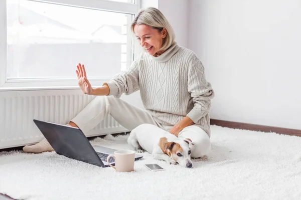 Mutlu Orta Yaşlı Köpekli Bir Kadın Rahat Beyaz Evinde Bilgisayarında — Stok fotoğraf