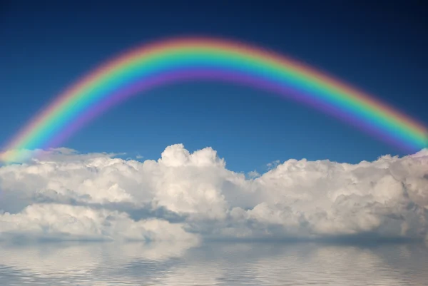 Nubes blancas esponjosas con arco iris en el cielo azul — Foto de Stock