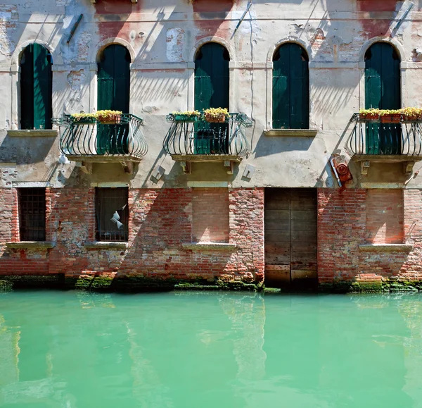 Voorkant van oude Venetiaanse huis staande in water — Stockfoto