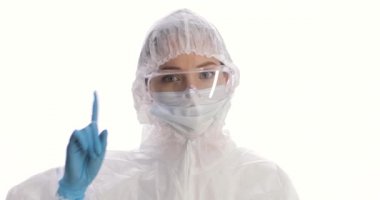 Koruyucu takım elbiseli kadın portresi, maske, eldiven ve gözlük, parmağını sallıyor. Coronavirus salgını karantinası. COVID-19 salgını.