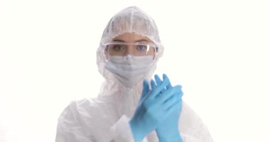 Beyaz arka planda koruyucu elbise, maske, eldiven ve gözlük takan kadın portresi. Coronavirus salgını karantinası. COVID-19 salgını. Enfeksiyon korkusu.
