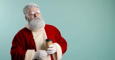 Moda, neşeli, mutlu Noel Baba hipster ve bir fincan kahve. Kahve içer ve mutludur. Mavi arkaplan