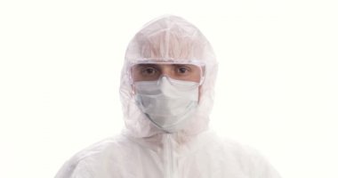 Koruyucu takım elbiseli, maske, eldiven ve gözlük takmış parmağını sallayan genç bir adamın portresi. Coronavirus salgını karantinası. COVID-19 salgını. Yakın plan..