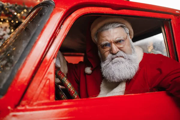 Retrato de un Santa Claus enojado conduciendo. Conductor agresivo, año nuevo, Navidad. Santa Claus se prepara para la Navidad. Fotos de stock libres de derechos