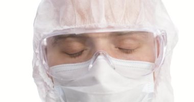 Yakın plan doktor yüzü, güvenlik gözlüklü gözler. Salgın sırasında koruyucu gözlük takan doktor portresi.