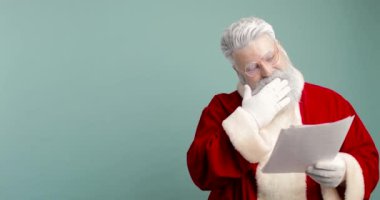 Mutlu Noel Baba, Aziz Nicholas Dilek Mektubu Çocuk Rüyaları Hediye Listesini Kontrol Ediyor. Memnun, memnun ve mutlu. Mavi arkaplan
