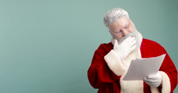 Gelukkige Kerstman, Sint Nicolaas Leest Wensen Brief, Checking Gift List of Kids Dreams. Hij is blij, tevreden en gelukkig. Blauwe achtergrond — Stockvideo