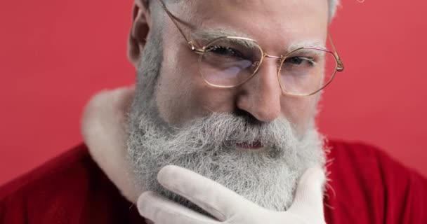 Stylový, brutální, krásný, módní portrét Santa Clause. Santa Claus se podívá do kamery, usměje se a narovná si vousy rukou. Vánoce, nový rok — Stock video