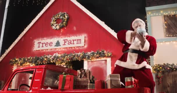 Nowoczesny Święty Mikołaj rozprasza maski ochronne w noworocznym studio urządzone stojąc w czerwonej ciężarówce z prezentów noworocznych. Koncepcja celebracji i radosnych ludzi. — Wideo stockowe