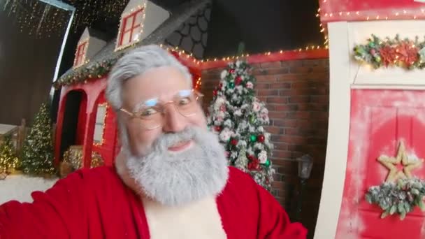 Un retrato de Santa Claus lindo filmándose en un hermoso estudio decorado de Año Nuevo. POV — Vídeos de Stock