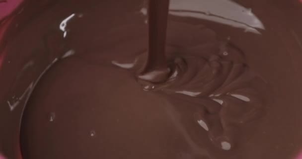 누군가가 실리콘 스파 툴라가 담긴 그릇에 초콜릿이나 초콜릿 크림을 휘젓고 있었어요. 클로즈업. 초코 렛을 만드는 사람들 이손으로 만든 유기농 초콜릿. — 비디오
