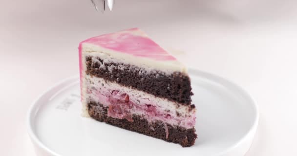 Un pezzo di torta al cioccolato con bacche su un piatto bianco è decorato con crema. Il concetto di fare e decorare torte e dessert. — Video Stock