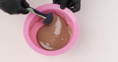 Silikon spatulayla çikolata ya da çikolata kreması karıştıran bir şefin yakın plan elleri. Çikolatalar el yapımı organik çikolata yapar..