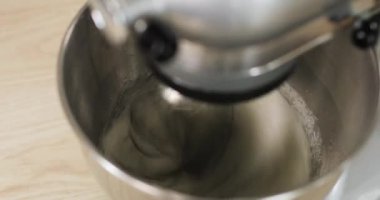 Baker kasedeki malzemeleri karıştırıyor hamur hamuru pişiriyor elektrikli karıştırıcı kullanıyor, yakın plan. Pişirme ve şekerleme adımları.