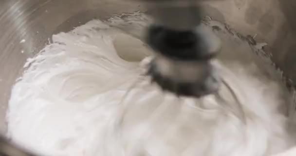 Cukrárna míchá přísady v kovové míse pro výrobu smetany nebo těsta na pečení a dezerty pomocí elektrického mixéru, detailní záběr. Kroky pečení a cukrářství. — Stock video