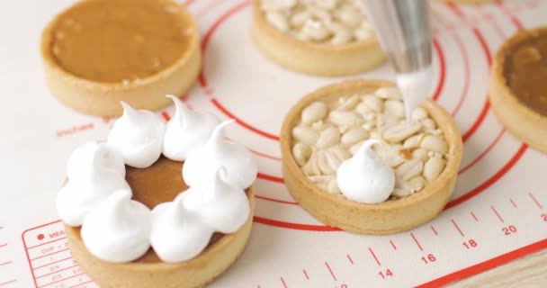 Biscuit tartlet decorated chef with cream from pastry bag, close-up. Preparation of cake at home bakery with piping bag. — Stock Video