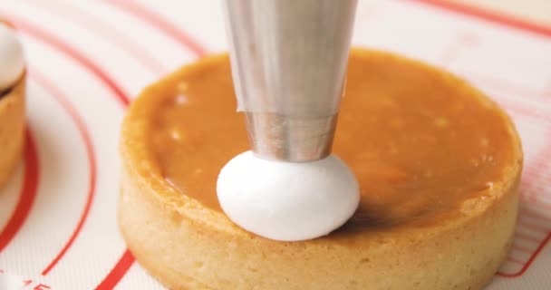 Close-up of biscuit tartlet decorated chef with cream from pastry bag. Preparation of cake at home bakery. — Stock Video