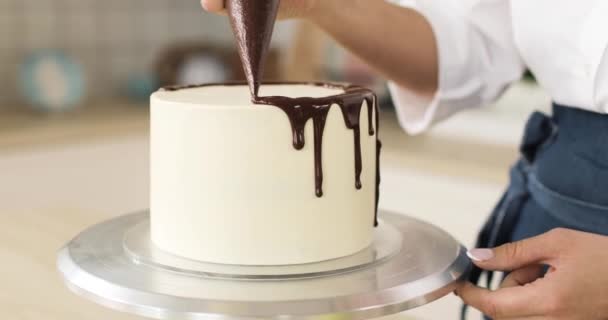 Bílý chutný dort zdobený pečivem s čokoládou. Rotace. Detailní záběr rukou. — Stock video