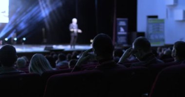 Seyircilerin bir iş konferansında arka planda oturması. Sözcü, diğer iş adamlarından oluşan farklı bir gruba sunum yapacak..