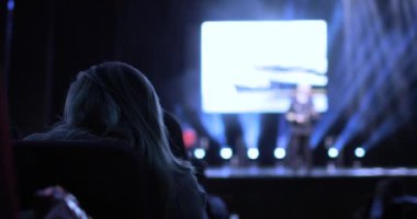 Bir iş konferansında oturan seyirciler arasındaki arka plan. Koridorda oturan tek kadına odaklan..