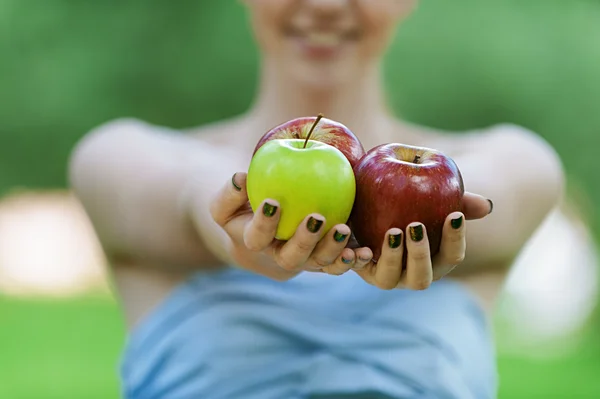 Young woman stretches apples — Stock Photo, Image