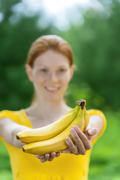 Young woman in yellow blouse with banana — Stock Photo, Image