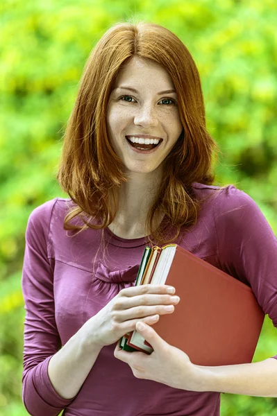 Red-haired beautiful young woman with books — Stock Photo, Image