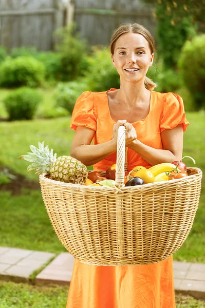 Молодая женщина с корзинами фруктов и овощей — стоковое фото
