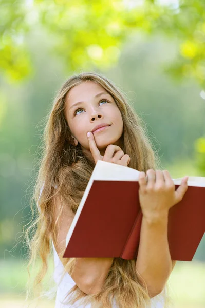 Adolescente lendo livro vermelho — Fotografia de Stock