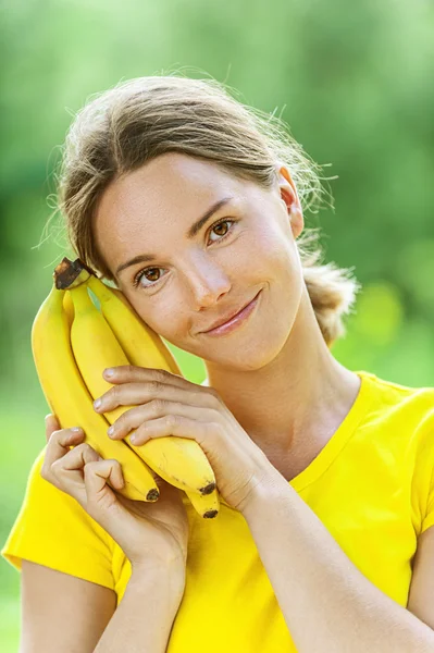 Νεαρή γυναίκα στην κίτρινη μπλούζα με μπανάνα — Φωτογραφία Αρχείου