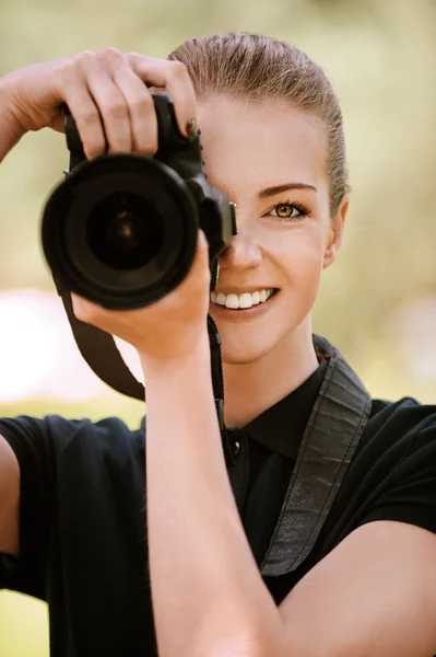 Sonriente joven mujer fotografías en cámara — Foto de Stock