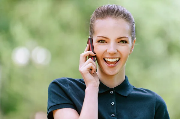 Χαμογελαστή νεαρή γυναίκα που μιλάει στο κινητό τηλέφωνο — Φωτογραφία Αρχείου