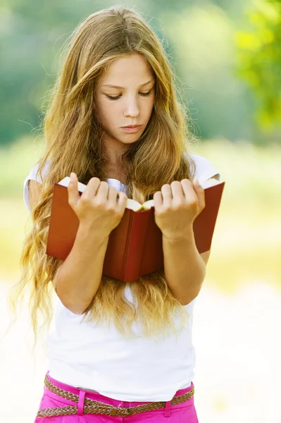 Adolescente lendo livro vermelho — Fotografia de Stock