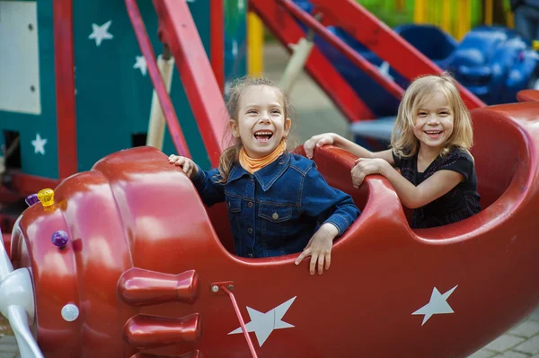 Grappige zusters op carrousel rit — Stockfoto