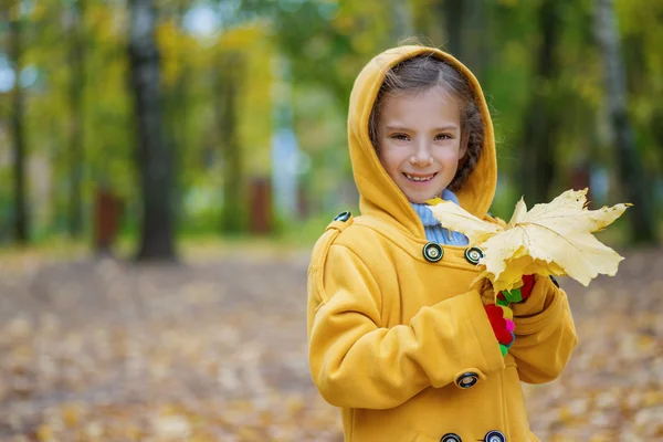 Beautiful smiling little girl in yellow hood — Stock Photo, Image