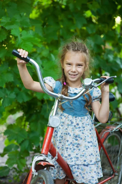 Bela menina sorridente com bicicleta infantil — Fotografia de Stock