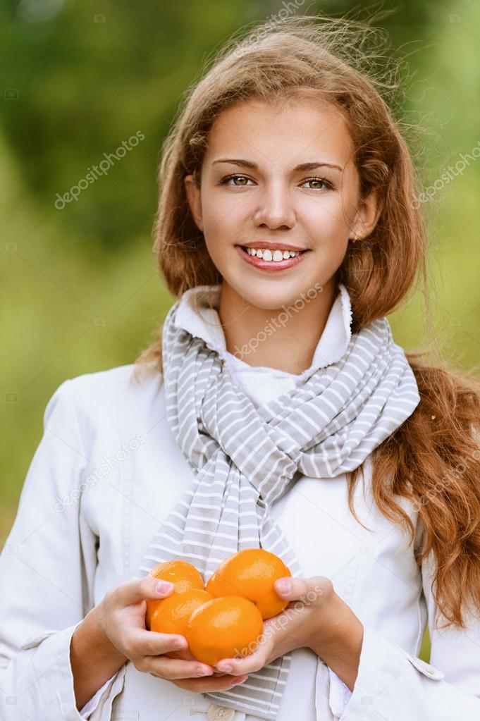 beautiful woman holding few juicy oranges