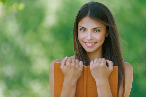 Glückliche junge Frau mit orangefarbenem Buch — Stockfoto