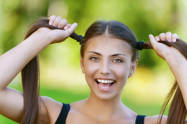 Feliz joven mujer sostiene sus colas — Foto de Stock