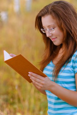 young woman reading orange book