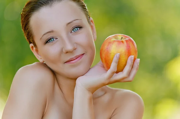 Mujer joven sosteniendo una manzana — Foto de Stock