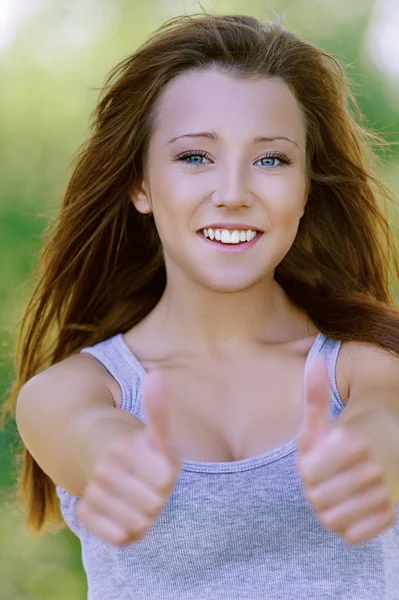 Sorridente giovane donna mostrando gesto — Foto Stock