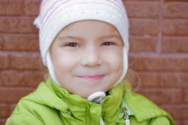 Yeşil ceketli gülümseyen küçük kız