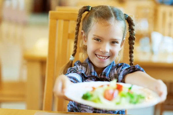 Sonriente chica sostiene a cabo plato de deliciosa comida —  Fotos de Stock