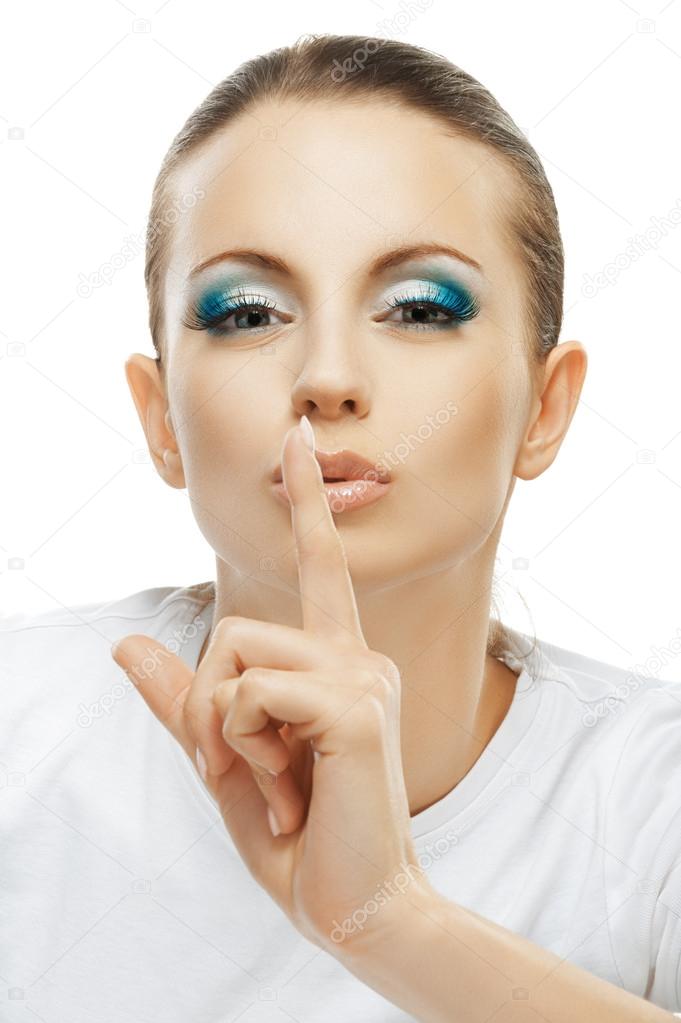 dark-haired woman raised index finger to lips