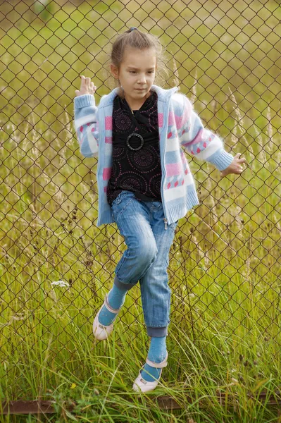 Маленькая девочка на металлической решетке — стоковое фото