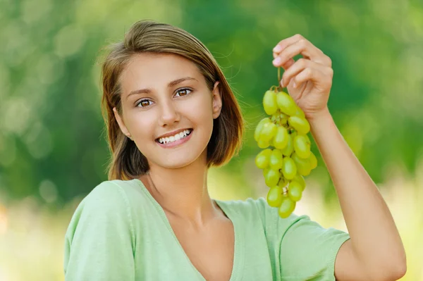 Молодая женщина с кучей винограда — стоковое фото