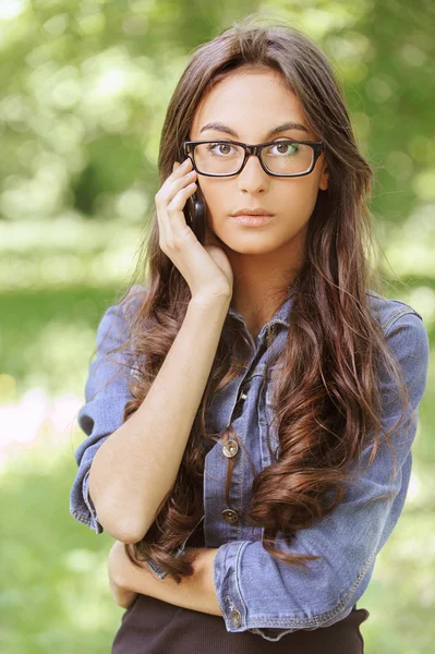 Giovane donna dai capelli scuri che parla con il cellulare — Foto Stock