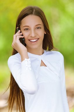 smiling teenage girl talking on mobile phone