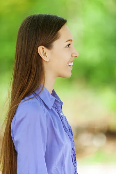 Smiling teenage girl in blue shirt profile — Stockfoto